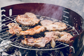 Close up on pork meat cooking on the barbeque outdoor grill food