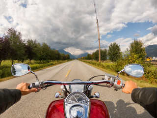Riding on a motorcycle on a beautiful scenic road surrounded by the Canadian Mountains. Taken in...