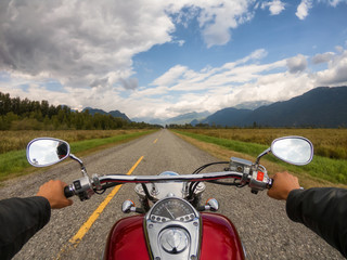 Riding on a motorcycle on a beautiful scenic road surrounded by the Canadian Mountains. Taken in...