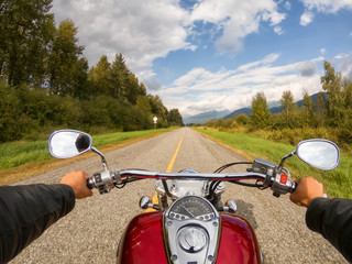 Riding on a motorcycle on a beautiful scenic road surrounded by the Canadian Mountains. Taken in...