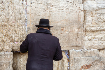 Religious Man, Hasidic Jew, dressed in black is praying by the Western Wall in the Old City. Taken in Jerusalem, Israel.