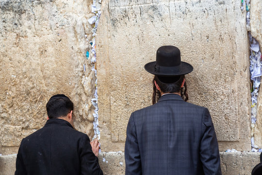 Religious Man, Hasidic Jew, dressed in black is praying by the Western Wall in the Old City. Taken in Jerusalem, Israel.