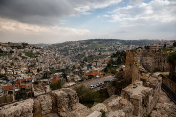 Fototapeta na wymiar Beautiful view of the Walls of Jerusalem surrounding the Old City with the cityscape in the background during a cloudy day. Taken near the Jerusalem, Israel.