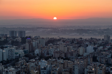 Aerial view of a residential neighborhood in a city during a vibrant and colorful sunrise. Taken in Netanya, Center District, Israel.
