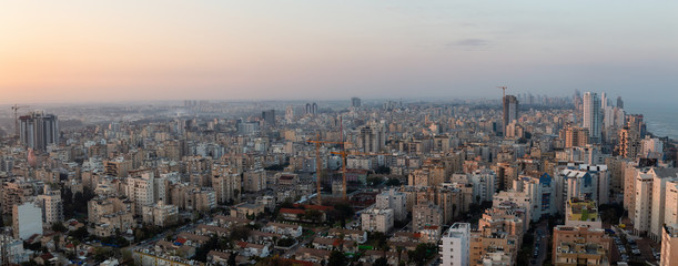 Aerial panoramic view of a residential neighborhood in a city during a vibrant and colorful sunrise. Taken in Netanya, Center District, Israel.