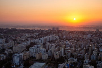 Aerial view of a residential neighborhood in a city during a vibrant and colorful sunrise. Taken in Netanya, Center District, Israel.