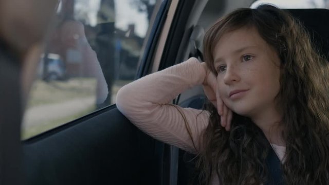 Girl smiling while looking through the car window