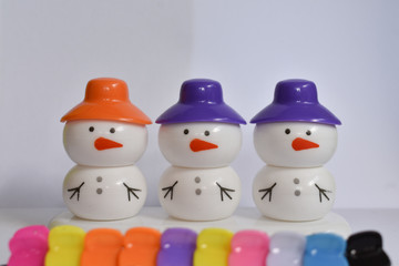 beautiful snowman with colorful caps