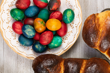 Traditional sweet bread in baking pan and Easter painted eggs, top view