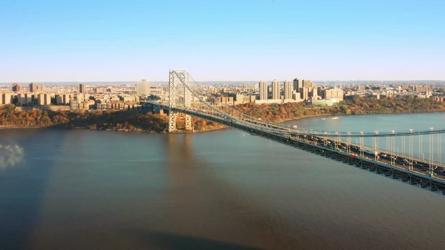 Establishing drone shot with George Washington Bridge filmed with a slow pullback camera movement, on late autumn afternoon.