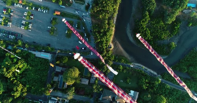 Aerial shot traditional Balinese kites flying in the air above seaside at sunset, Sanur, Bali, Indonesia. 4K