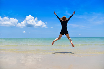 Fototapeta na wymiar Women jumping on sea beach blue sky background Travel in Summer Holidays