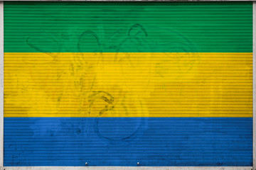 Close-up of old metal wall with national flag of Gabon. Concept of Gabon export-import, storage of...