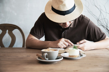 Relax Asian man drink coffee and read book in a modern style coffee shop - people with coffee cup easy lifestyle concept