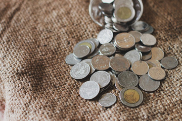 Saving money, Thai money in the glass on the sack of brown background