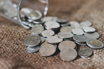 Saving money, Thai money in the glass on the sack of brown background