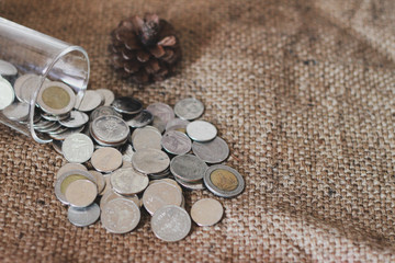 Saving money, Thai money in the glass on the sack of brown background