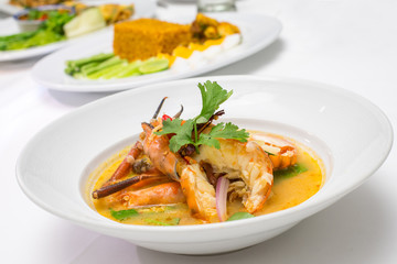 Tom Yum Goong - Thai hot and spicy soup with shrimp - with another thai food in background