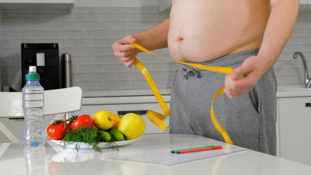 fat man measuring his waist, healthy eating, healthy lifestyle concept, fitness diet