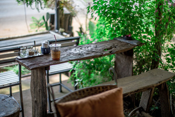 The blurred background of the shop decoration (small glass of water, vase, flowers) that is decorated on the wall or placed on a wooden table for customer service to relax during the service