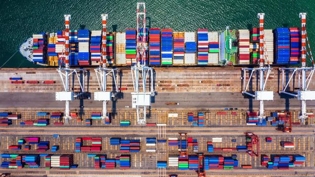 4k Hyper lapse aerial view container cargo ship loading and unloading in deep sea port, Aerial top view of logistic import export transportation business by container ship in open sea.