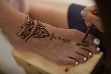master mehndi paint on the foot pattern of the mandala