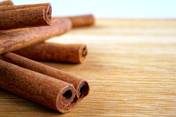 Cinnamon sticks on a woody brown background.