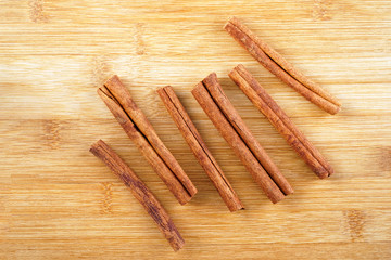 Cinnamon sticks on a woody brown background.