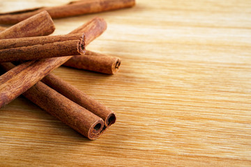 Cinnamon sticks on a woody brown background.