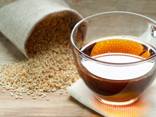 Sesame oil in one gleass on wood table.