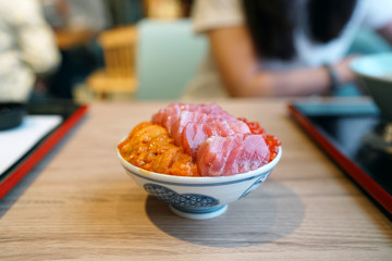 Otoro, ikura and uni donburi - Japanese rice bowl topped with fresh tuna, sea urchin roe, salmon roe, Japanese traditional food.