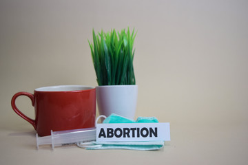 Abortion text, grass pot, coffee cup, syringe, and face green mask. Healtcare/Medical and Business...
