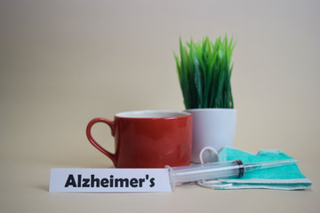 Alzheimer's text, grass pot, coffee cup, syringe, and face green mask. Healtcare/Medical and Business concept