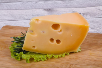 Maasdam cheese  in the board served salad leaves