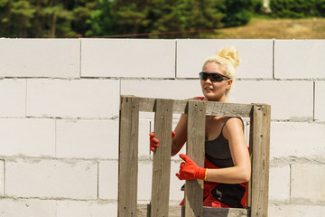 Woman working with pallets on construction site