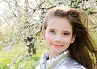 Portrait of adorable smiling little girl child outdoors in spring day