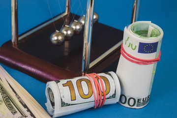 a lot of money dollars and newton balls on a blue background