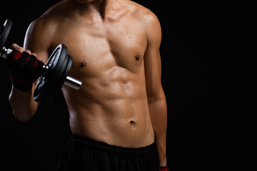 Fototapeta na wymiar Closeup of a strength fitness body with dumbbell. Fit young man with beautiful torso. Beginner Bodybuilder and muscular body concept.