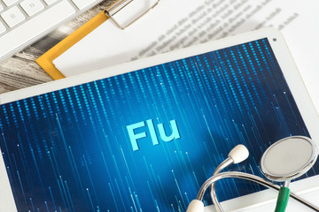 Ein Tablet PC, Stethoskop und Warnung vor Grippe