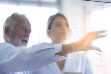 Obraz premium Male and female scientists are discussing details for testing and analysis to find the results of medical research. Scientific and chemical concepts