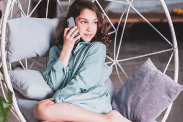 Kids concept, pretty nice girl talking to phone at cozy home, child or teen lifestyle 