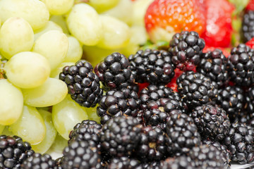 Colorful assorted mix of fresh organic blackberries, strawberries and grapes.