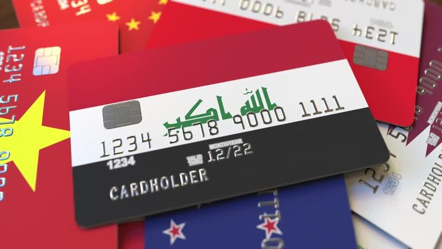 Many credit cards with different flags, emphasized bank card with flag of Iraq