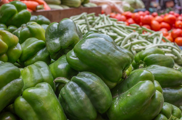 A bunch of green bell peppers at a local market