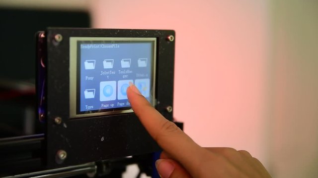 Woman finger press on screen to control 3D printer