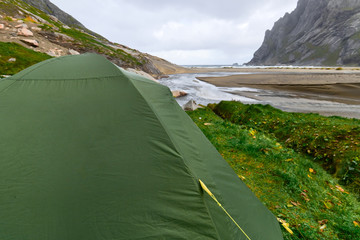 Green tent standing at Bunes Beach on Lofoten Islands in Norway