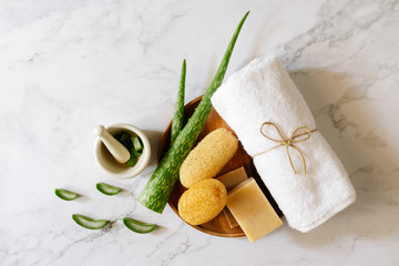 Top view of spa background with aloe vera, towels, soap, Luffa and mortar.