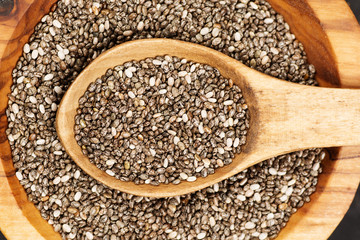 Chia seeds in organic dish on dark concrete background. Top view. Healthy food concept.
