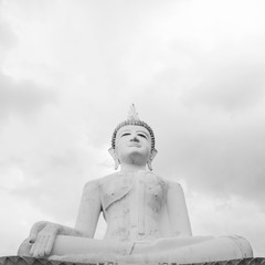 Black and white image, a large Buddha image in Surin, Thailand on a cloudy day.