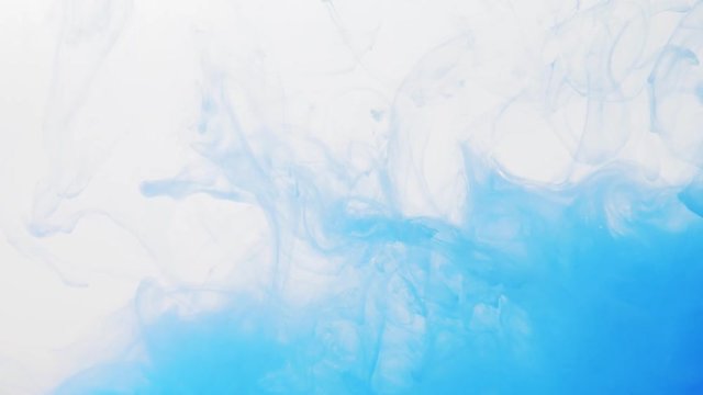 Blue acrylic paint dissolving into a water, close shot. Blurred background. Abstract acrylic clouds moving slowly in liquid. Blue ink in water. Abstract pattern of paint disappearing in water